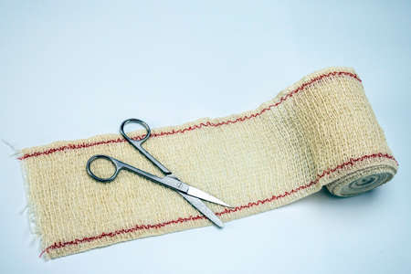 Surgical scissors on a bandage, conceptual image