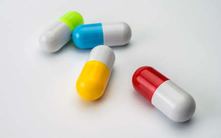 Several capsules of different color isolated on white background, conceptual imageの写真素材