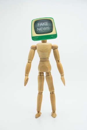 Articulated doll with television head appears fake news, isolated in white background, conceptual imageの写真素材