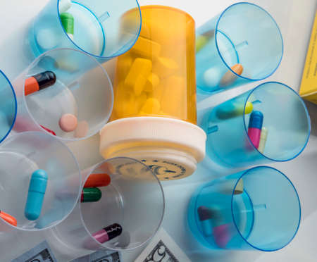 Some medicines next to a block of tickets of dollar, conceptual imageの写真素材