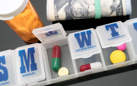 Pillbox next to banknotes of dollar, conceptual image