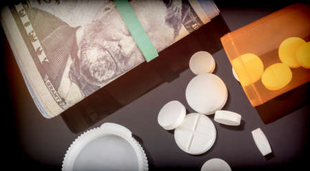 Boat of white pills along with tickets of dollar, concept of sanitary copayment