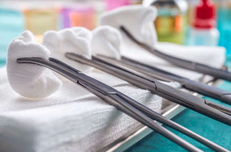 Scissors surgical with torundas in an operating theater, composition horizontal, conceptual image