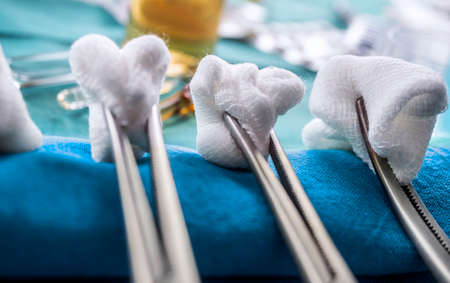 Scissors surgical with torundas in an operating theater, composition horizontal, conceptual image