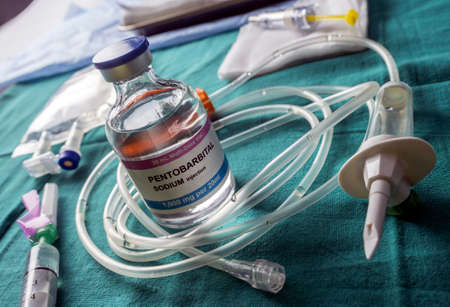 Vial with doses of pentobarbital, Debate between life and death, religious belief in the face of...