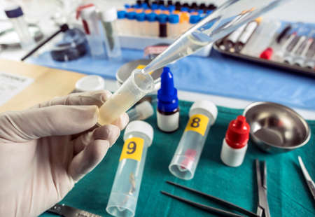 Expert police examines semen for DNA evidence, conceptual image