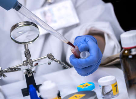 Scientific police extracts crime scene blood in forensic laboratory to verify DNA, conceptual image
