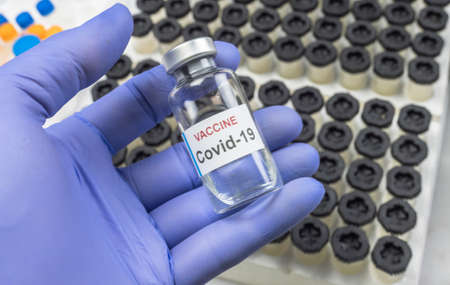 Scientist holds a coronavirus vaccine, conceptual image