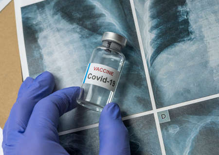Scientist holds a coronavirus vaccine, conceptual image