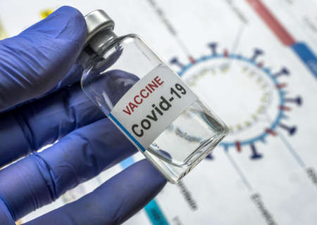 Scientist holds a coronavirus vaccine, conceptual image