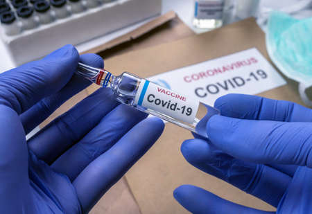 Scientist holds coronavirus vaccine in hospital, conceptual imageの写真素材