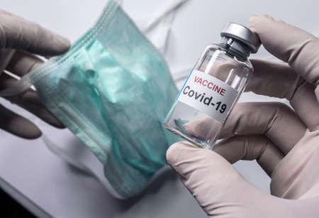 Scientist holds a coronavirus vaccine, conceptual image
