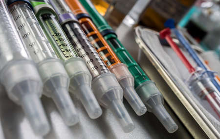 Syringes of insulin medication next to medicine vials prepared in hospital, conceptual image