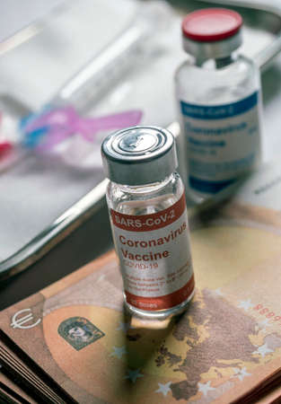 Coronavirus vial on euro banknotes, conceptual image