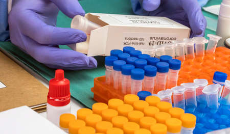 Nurse unpacking box with Covid-19 PCR kit in hospital warehouse, conceptual image