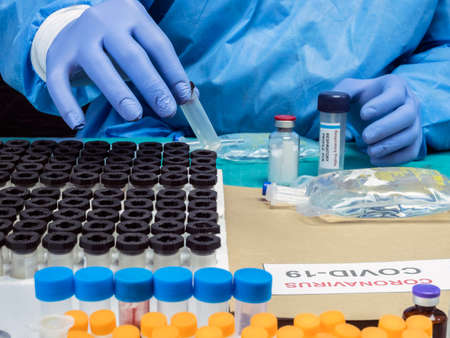 Nurse unpacking box with Covid-19 PCR kit in hospital warehouse, conceptual image