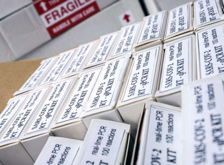 Nurse unpacking box with Covid-19 PCR kit in hospital warehouse, conceptual imageの写真素材