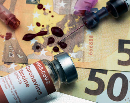 blood syringe with covid-19 vaccine on euro banknotes, conceptual ideaの写真素材