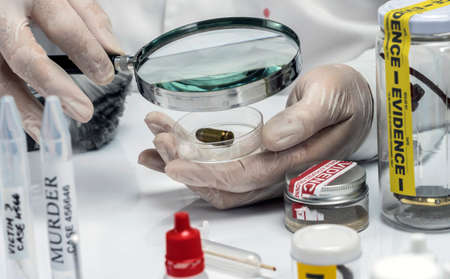 Scientific police examining a bullet cap in ballistic Laboratory, conceptual image
