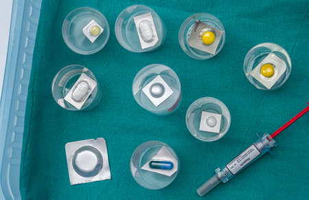 Diverse medication in glasses monodose along with heparin injectors in hospital, conceptual image
