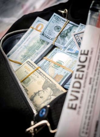 Black duffel bag full of dollar notes in criminal investigation unit, conceptual imageの写真素材