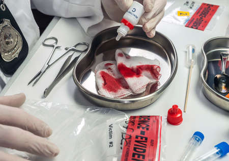 Police scientist examines bloodstained gauze from a drug overdose case, conceptual image