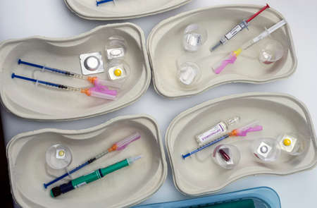Diverse medication in glasses monodose along with insulin injectors in hospital, conceptual image