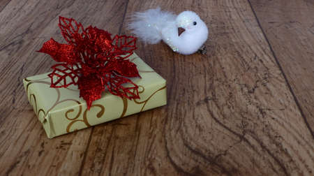 gift decorated with a poinsettia and a white birdの写真素材