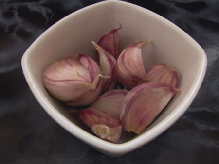 pungent garlic in a white porcelain bowlの写真素材