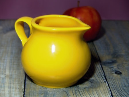 yellow milk jug and red appleの写真素材