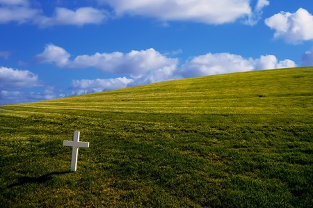 Bright white cross on grassy background の写真素材