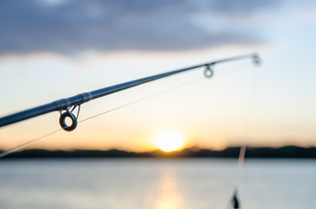 fishing on a lake before sunsetの写真素材