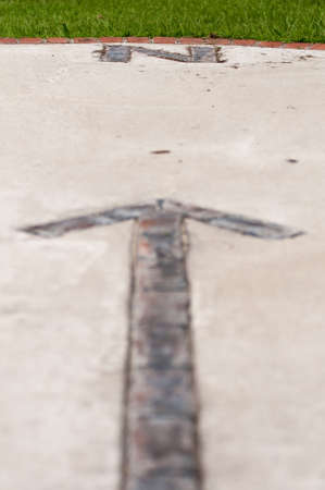 brick paver north arrow compass embedded in concreteの写真素材