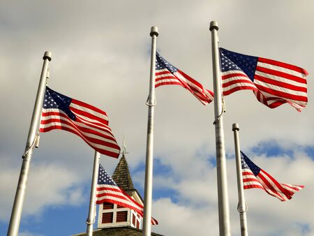 red white and blue flags on a pole with american architectureの写真素材