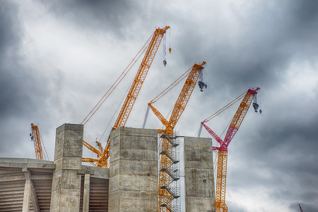 heavy construction cranes erecting concrete buildingのeditorial素材