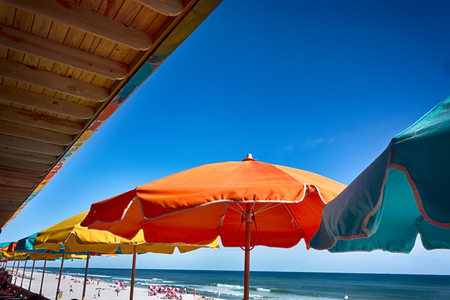 colorful umbrellas at a restaurant by the beachの写真素材