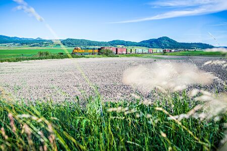 train moving through flathead reservation in montana mountainsのeditorial素材