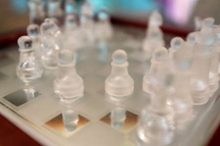 glass chess figurines playing game on chess boardの写真素材