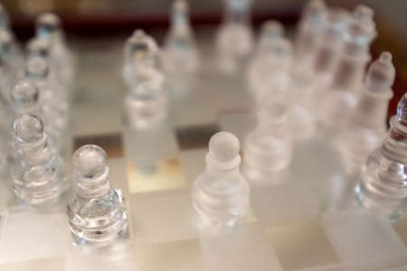 glass chess figurines playing game on chess boardの写真素材
