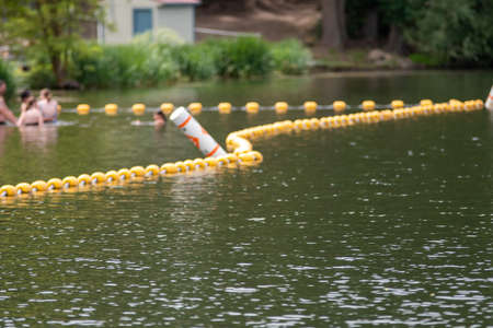 Swimming area border marked with red and orange floatsの写真素材