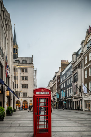 London Red Telephone Boxes on the Street. Black and White Buildings and Street with Red London Telephone Boxesの写真素材