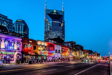 Nashville Tennessee Broadway Night Street with Neon Lit Bars and AT&T Building Rising Above Downtown Skyline