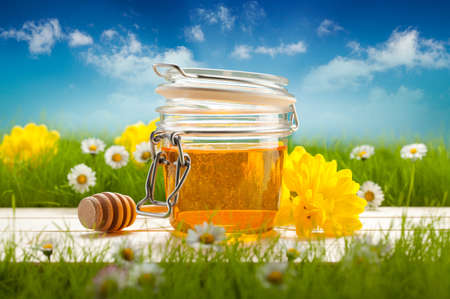 Jar of honey and spring flowers の写真素材