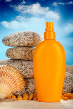 Sunbath - suntan oil, shell and stonesの写真素材
