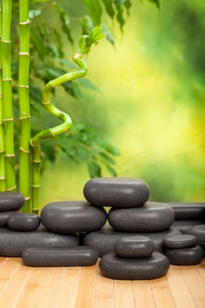 Black spa stones on green bamboo backgroundの写真素材