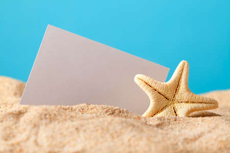 Starfish and blank card on beachの写真素材