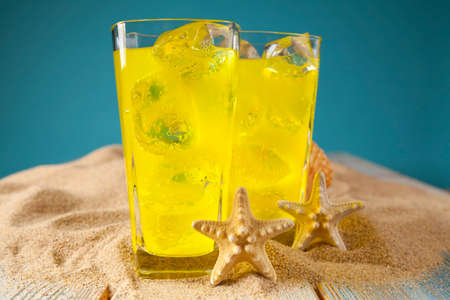 Two yellow drinks on blue backgroundの写真素材