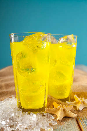 Cold drinks, shells and ice cubes on the beachの写真素材