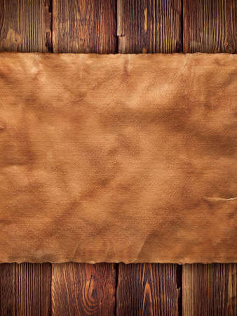 Creased paper sheet on wooden wall backgroundの写真素材