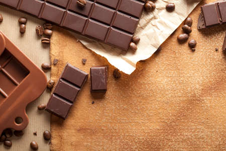 Dark chocolate and coffee beans on old paper background